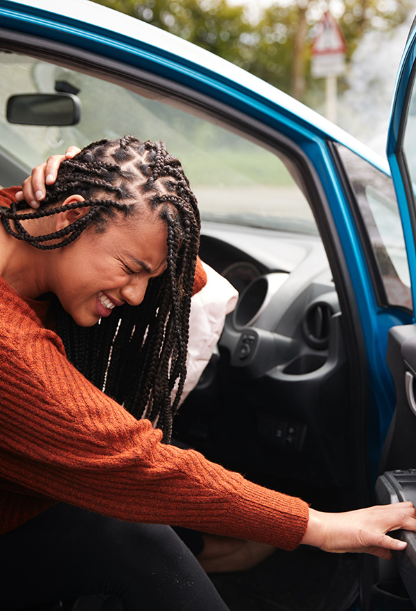 Female Motorist With Whiplash Injury In Car Crash Getting Out Of Vehicle